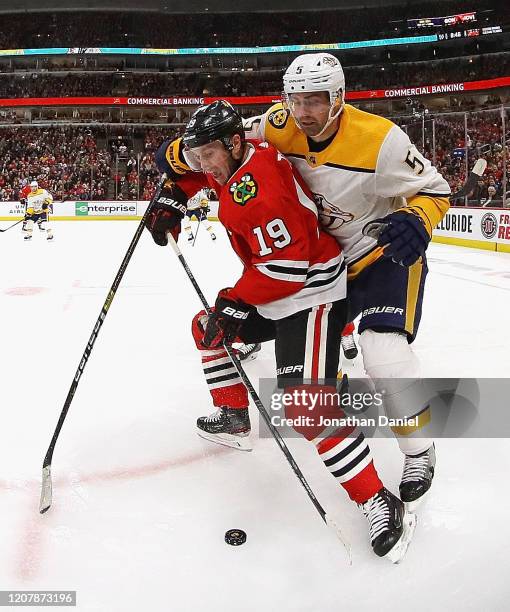 Jonathan Toews of the Chicago Blackhawks is pressured by Dan Hamhuis of the Nashville Predators at the United Center on February 21, 2020 in Chicago,...