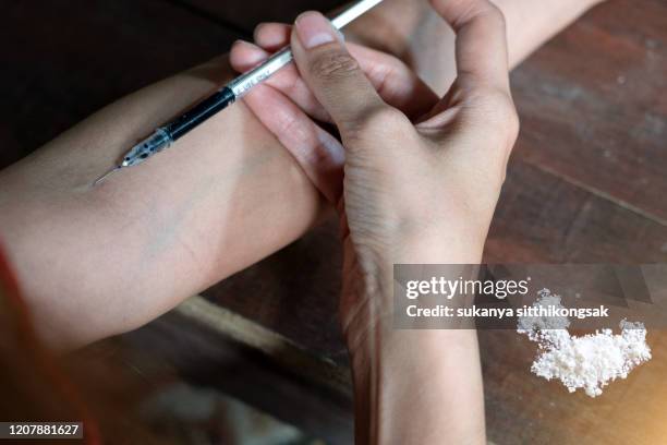 high angle view of hand woman drug addict injecting heroin into her arm. - heroin addict arm 個照片及圖片檔