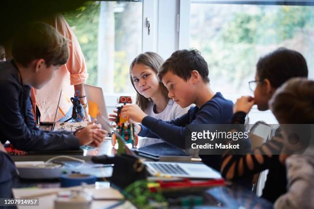 male and female students working with science project in training class - preteen girl models stock pictures, royalty-free photos & images