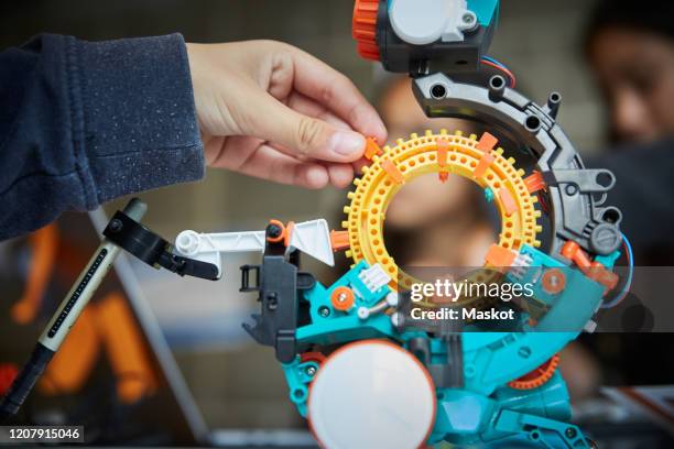 cropped hand of male student with science project in classroom - stem stock pictures, royalty-free photos & images