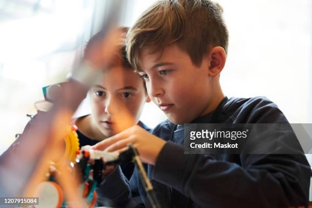 male students working with robot for science project in classroom - differential focus fotografías e imágenes de stock
