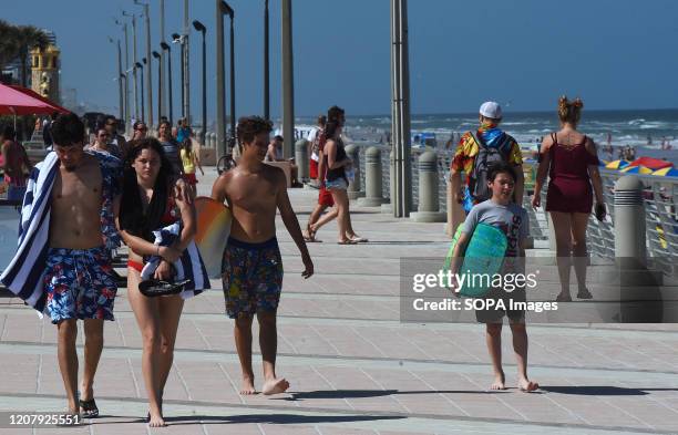 People walk the boardwalk during a spring break at Daytona Beach after Florida Governor Ron DeSantis refused to order the state's beaches closed as...