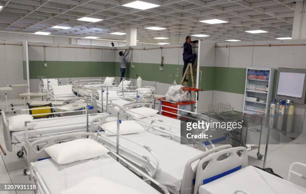 Iranian workers set up a makeshift hospital inside the Iran Mall, northwest of Tehran, on March 21, 2020 amid the coronavirus outbreak. - Iran said...