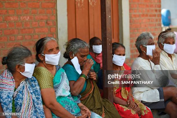 Leprosy affected people, wear facemasks being distributed by a non-governmental organisation amid concerns over the spread of the COVID-19 novel...