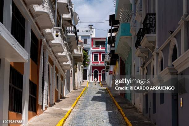 Man walks on an empty street in one of the tourist area of Old San Juan city in San Juan, Puerto Rico on March 21, 2020. Almost one billion people...