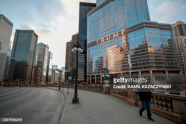 Man walks by Trump International Hotel and Tower in Chicago, Illinois, on March 21, 2020. - Almost one billion people were confined to their homes...