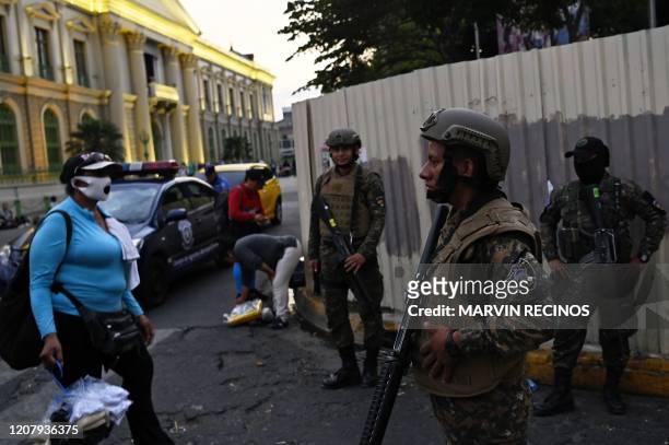 Security forces, including the police and the army, clear people from the historic centre of San Salvador as part of the government's emergency...