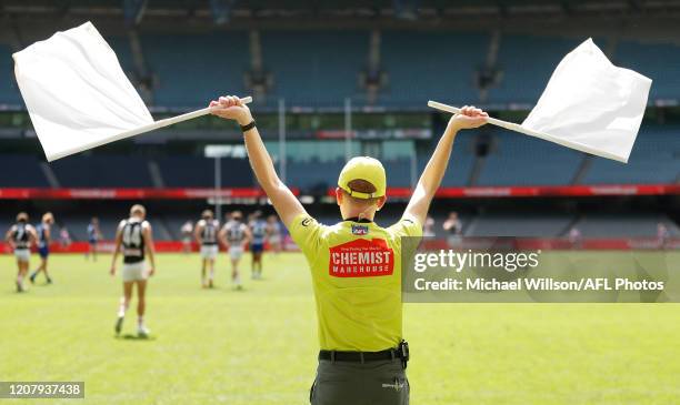 The goal umpire waves his flags during the 2020 AFL Round 01 match between the North Melbourne Kangaroos and the St Kilda Saints at Marvel Stadium on...