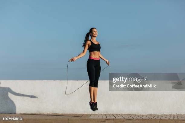 ジャンプロープで訓練する若い女性 - 縄跳びの縄 ストックフォトと画像