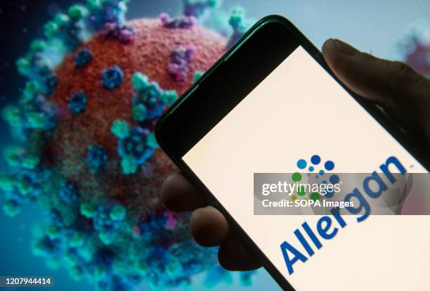 In this photo illustration the Irish-domiciled pharmaceutical company Allergan logo seen displayed on a smartphone with a computer model of the...