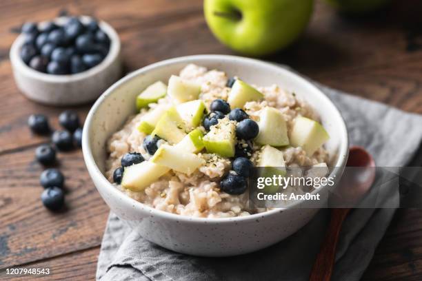 oatmeal porridge with green apple and blueberries - carbohidrato fotografías e imágenes de stock