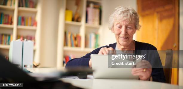 senior woman using the web to keep in touch - browsing the internet stock pictures, royalty-free photos & images