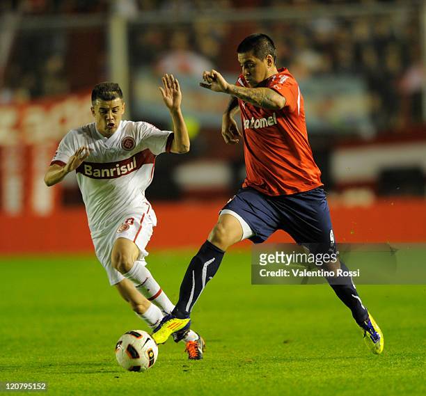Andres D'alessandro of Internacional fights for the ball with Leonel Nuñez of Independiente during a match as part of the 2011 Recopa Sudamericana...