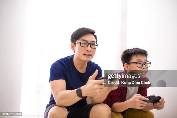 papa en zoon die videospel gelukkig spelen - malaysia father and son stockfoto's en -beelden