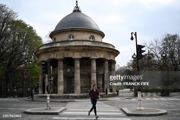 Jogger runs in front of the Monceau Park rotunda in Paris, on March 22 on the sixth day of a strict lockdown in France aimed at curbing the spread of...