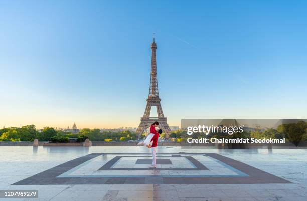 lovely couple in front of the eiffel tower, paris, france - couple paris stockfoto's en -beelden