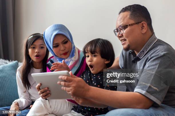 playful young family surfing the net on digital tablet - surprised woman looking at tablet stock pictures, royalty-free photos & images