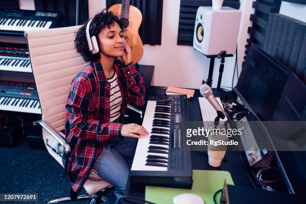 girl playing keyboards and recording music in the studio - songwriter stock pictures, royalty-free photos & images