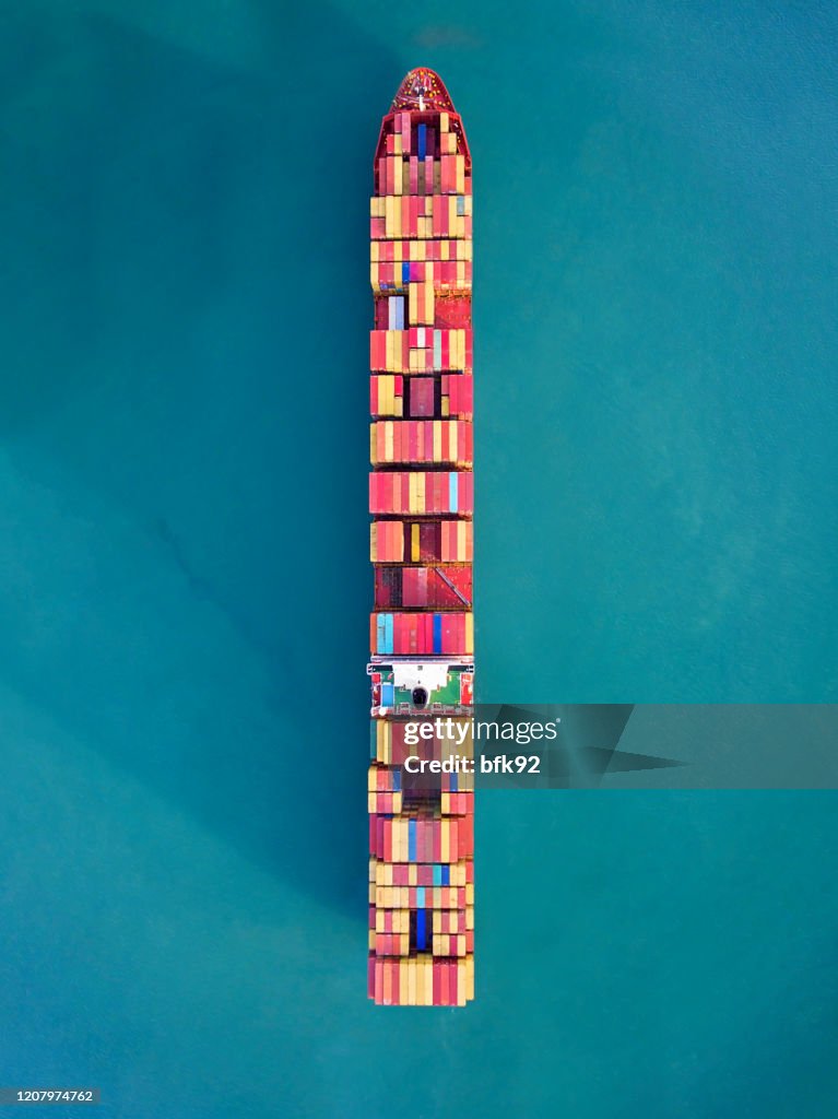 Flygvy över containerfraktfartyg som transporterar containerlåda för import- och exportlogistik i havet.