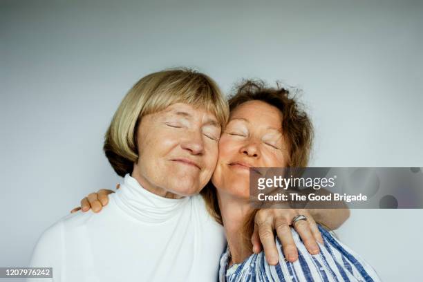 portrait of mother and daughter on white background - studio relations stock pictures, royalty-free photos & images