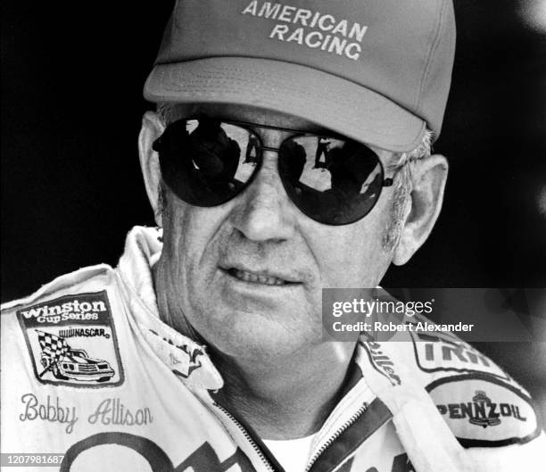 Driver Bobby Allison talks with friends in the speedway garage prior to the start of the 1987 Pepsi Firecracker 400 race at Daytona International...