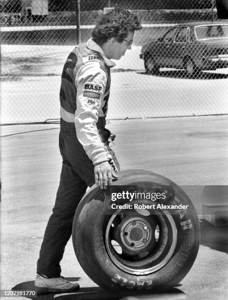 Driver Alan Kulwicki rolls a tire in the speedway garage prior to the start of the 1987 Pepsi Firecracker 400 race at Daytona International Speedway...