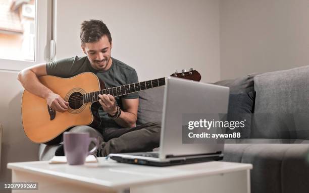 practice in living room - acoustic guitarist stock pictures, royalty-free photos & images