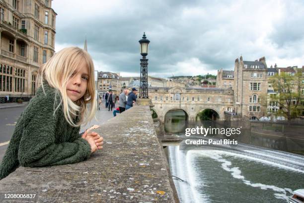 blonde boy in front of the river avon and famous pulteney bridge, bath, uk - bath inglaterra - fotografias e filmes do acervo