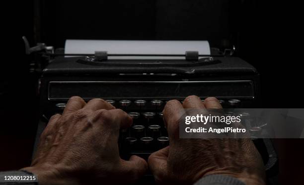 an old typewriter operated by a writer of our day - a melancholy and suggestive scene. - escribir bildbanksfoton och bilder