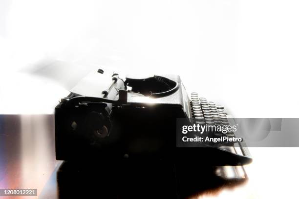 an old typewriter operated by a writer of our day - a melancholy and suggestive scene. - escribir stock-fotos und bilder