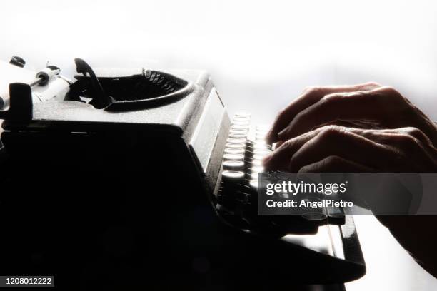 an old typewriter operated by a writer of our day - a melancholy and suggestive scene. - escribir bildbanksfoton och bilder