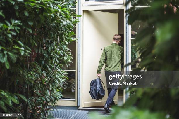 male entrepreneur with bag entering in house - entering building stock pictures, royalty-free photos & images