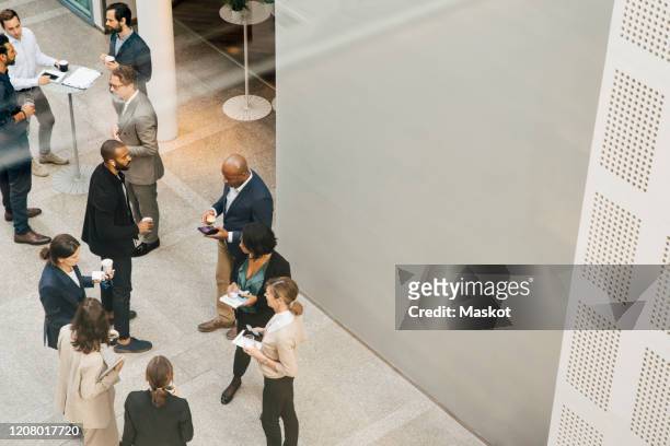 high angle view of male and female entrepreneurs talking outside office - conference centre stock-fotos und bilder
