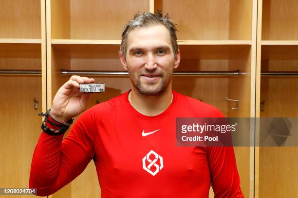 Alex Ovechkin of the Washington Capitals poses for a photo with the puck scored for his 700th NHL goal against the New Jersey Devils at Prudential...