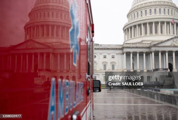 An ambulance sits outside the US Capitol in Washington, DC, March 23 as the Senate continues negotiations on a relief package in response to the...