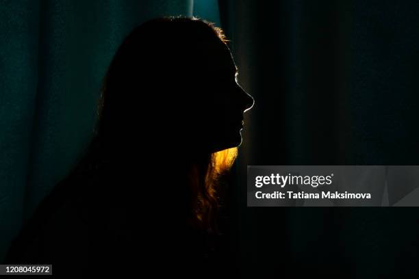 young woman silhouette in dark. - girl silhouette stock-fotos und bilder