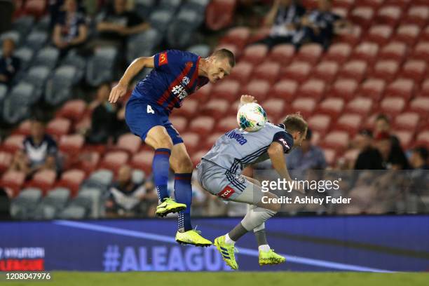 Nigel Boogaard of the Newcastle Jets heads the ball over Ola Toivonen of Melbourne Victory during the round 20 A-League match between the Newcastle...