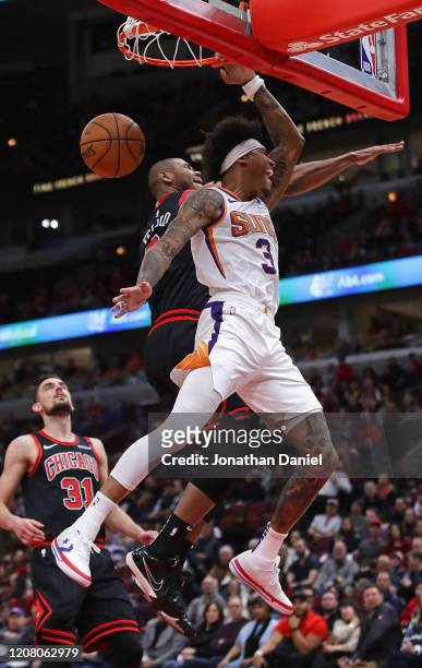 Kelly Oubre Jr. #3 of the Phoenix Suns dunks against Cristiano Felicio and Tomas Satoransky of the Chicago Bulls at the United Center on February 22,...