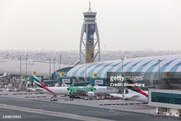 Passenger aircraft, operated by Emirates, stand beside the terminal building at Dubai International Airport in Dubai, United Arab Emirates, on...