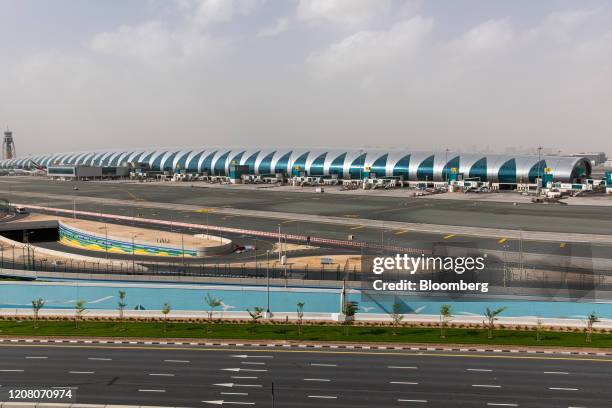 Docking bays for passenger aircraft, operated by Emirates, stand empty in Terminal Three beyond a deserted access road at Dubai International Airport...