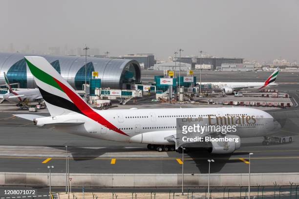 An Airbus SE A380-800 aircraft, operated by Emirates, taxis past the terminal at Dubai International Airport in Dubai, United Arab Emirates, on...