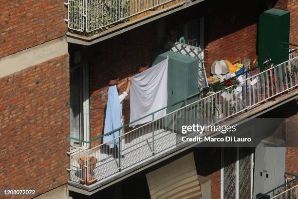 Woman who appears to have a veil is spreading her sheets to dry on her balcony during lockdown on March 23, 2020 in Rome, Italy. As Italy extends its...