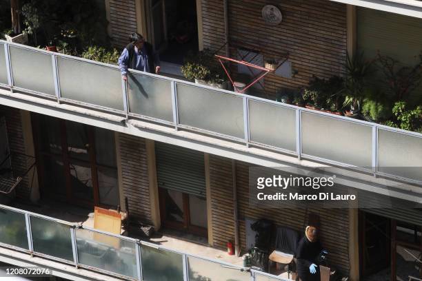 Two women stand on their balconies during lockdown on March 23, 2020 in Rome, Italy. As Italy extends its nationwide lockdown to control the spread...
