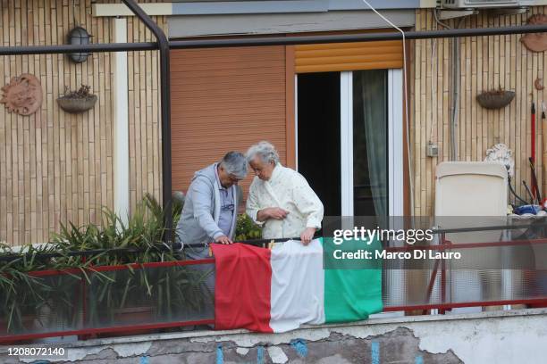 Couple stand on their balcony on March 22, 2020 in Rome, Italy. As Italy extends its nationwide lockdown to control the spread of COVID-19, its...