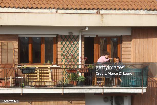 Three friends have lunch with spaghetti on their balcony on March 22, 2020 in Rome, Italy. As Italy extends its nationwide lockdown to control the...