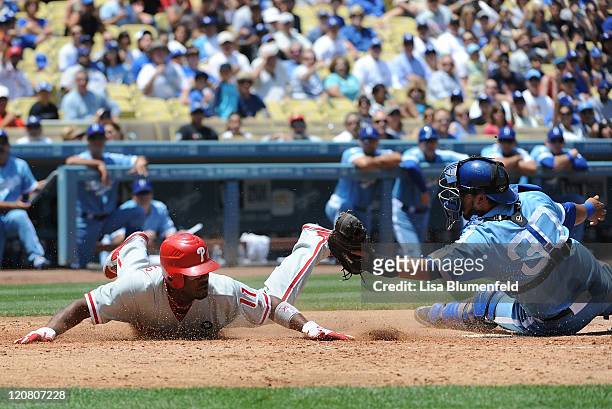 Jimmy Rollins of the Philadelphia Phillies tagged out at home plate by Dioner Navarro of the Los Angeles Dodgers in the third inning at Dodger...