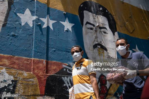 Men wearing a protective masks walk in Petare slum on March 23, 2020 in Caracas, Venezuela. While Nicol·s Maduro declared national quarantine, the...