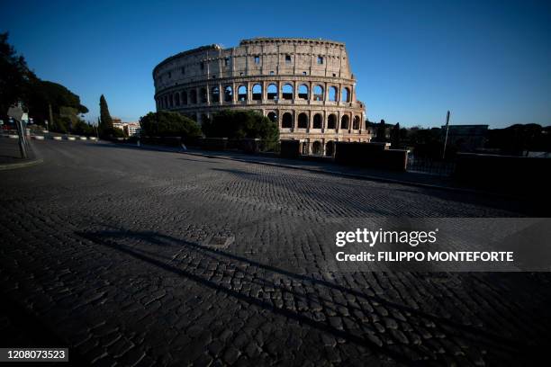 Picture taken on March 23, 2020 shows a view of the Colosseum monument along a deserted Via dei Fori Imperiali in Rome, during the country's lockdown...