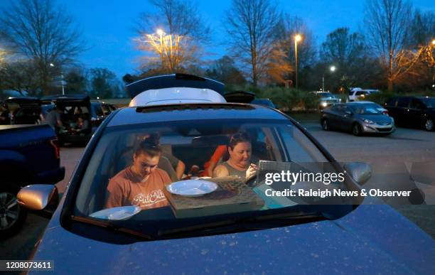 Maggie Weddle, left, and Janae Aardal fill out their bingo cards while playing parking lot bingo at Tavern on the Green at Eagle Ridge in Garner,...