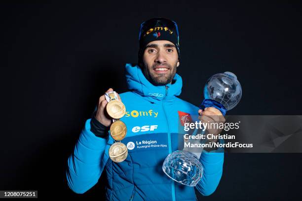 Martin Fourcade of France presents his medals and trophy after the Men 12.5 km Pursuit Competition at the BMW IBU World Cup Biathlon Kontiolahti on...